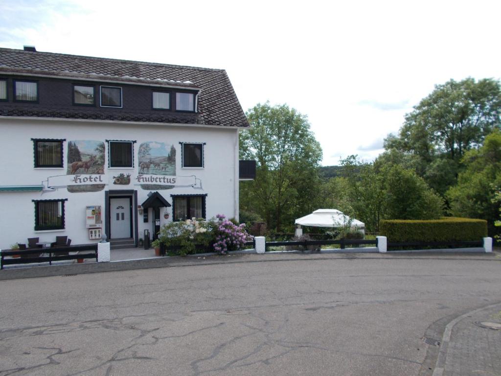 a large white building with a bench in front of it at Pension Hubertus in Oberraden
