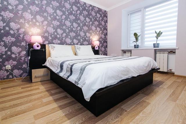a bedroom with a large bed with purple wallpaper at VIP Apartment ob Gorkogo Square in Sumy