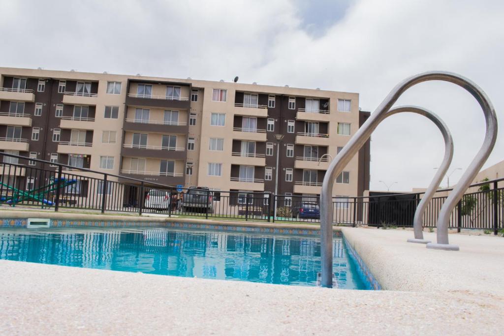 - une piscine en face d'un immeuble dans l'établissement Condominio Mistral V, à La Serena