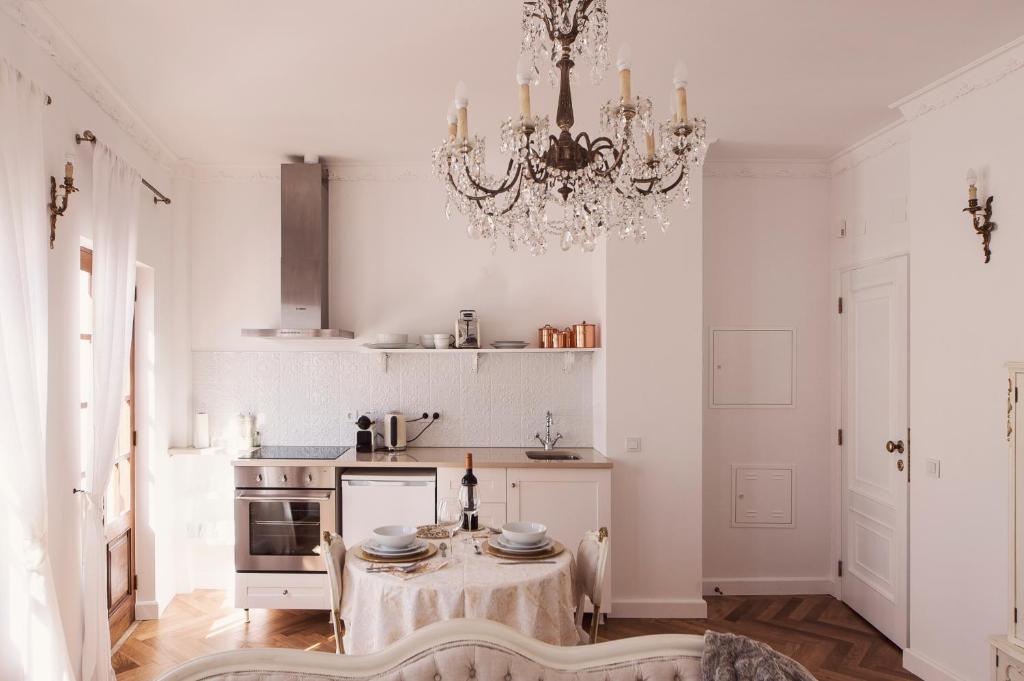 a white kitchen with a table and a chandelier at The Salt House in Olhão