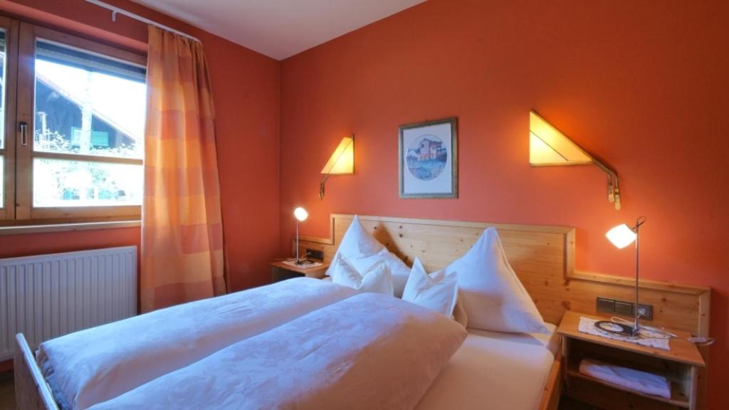 a bedroom with a large white bed and a window at Alt Mösern in Seefeld in Tirol