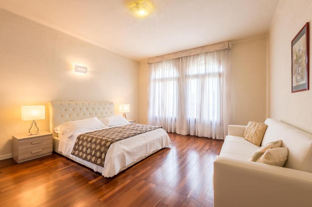 um quarto com uma cama e um sofá em Appartamento Masha em Veneza