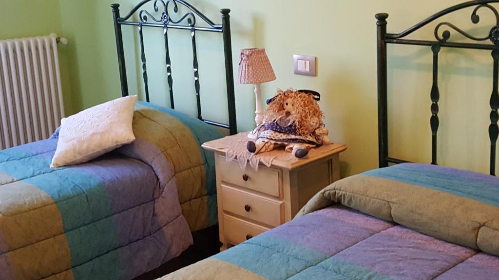 - une chambre avec deux lits et une table avec une lampe dans l'établissement Residence Villa Valsi, à Santo Stefano di Sessanio