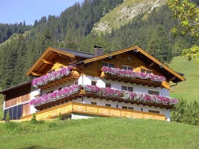 ein Gebäude mit Blumen auf der Seite in der Unterkunft Alpenview Lechtal in Holzgau