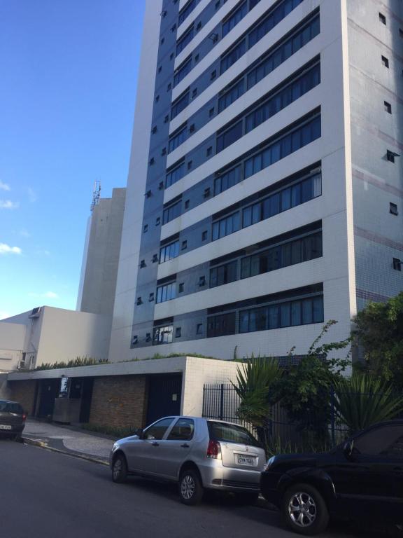 dois carros estacionados em frente a um edifício alto em Studio Everest Flats no Recife