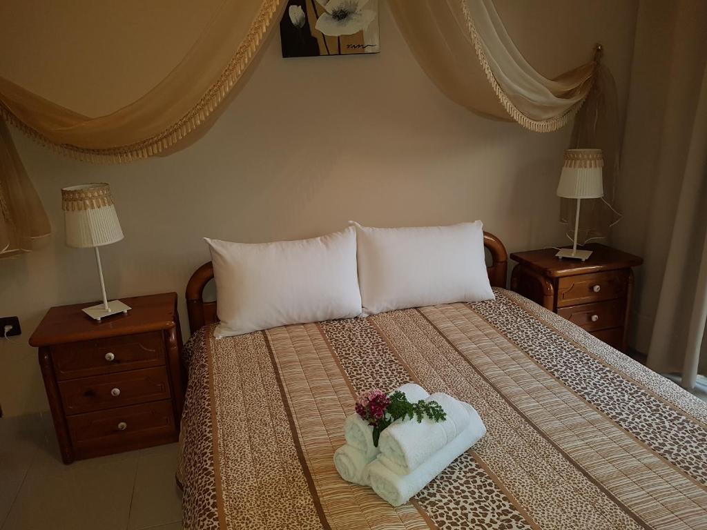 a bedroom with a bed with a bouquet of flowers on it at Georgia Old Town Apartments in Rhodes Town