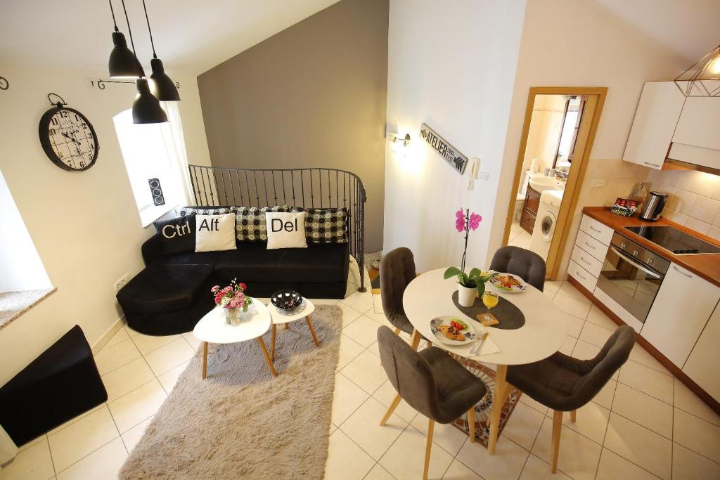 a kitchen and a living room with a table and chairs at Stomorica Apartments in Zadar