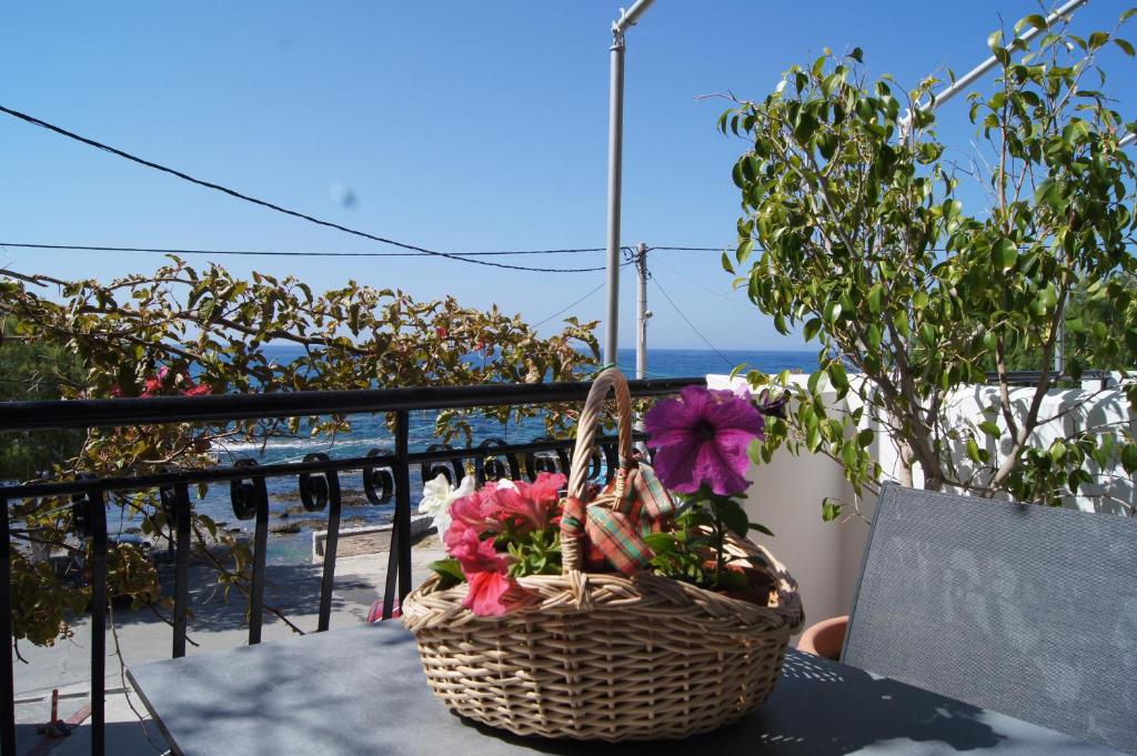 a basket of flowers sitting on a table on a balcony at Gio-Ma in Plakias
