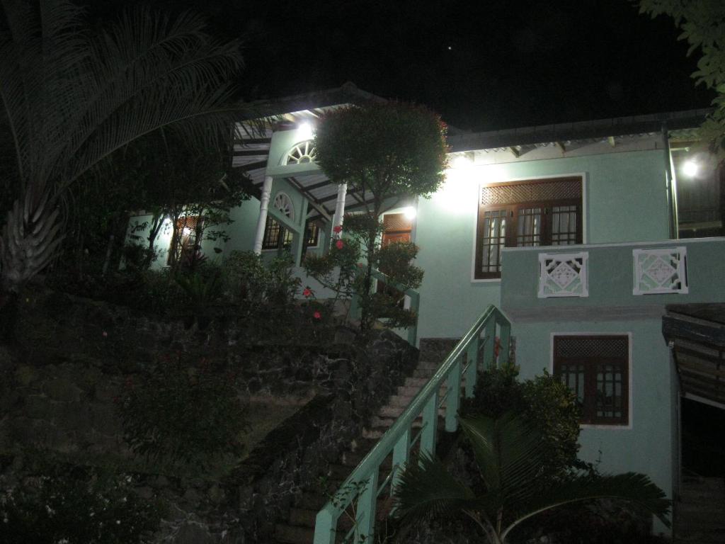 una casa por la noche con una escalera que conduce a ella en Sinharaja Holiday Bungalow, en Tinniyawala