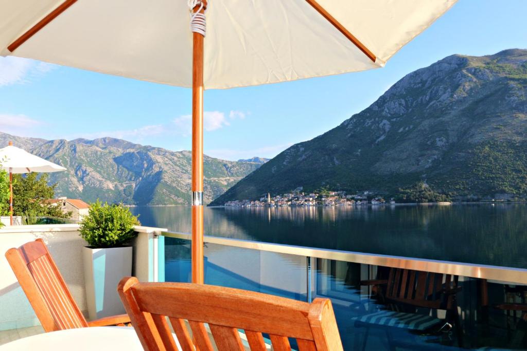 a table with an umbrella and a view of the water at Apartment MiraMare in Kotor