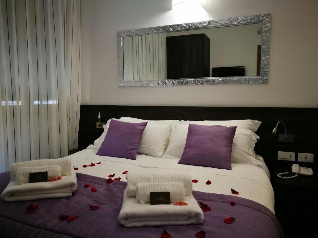 a bedroom with a large bed with flowers on it at Hotel Tre Rose in Caorle