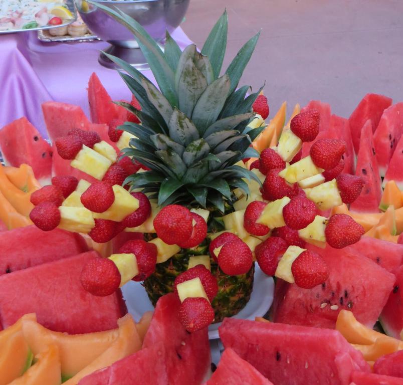 a plate of fruit with a pineapple and strawberries at Hotel Maxim in Caorle
