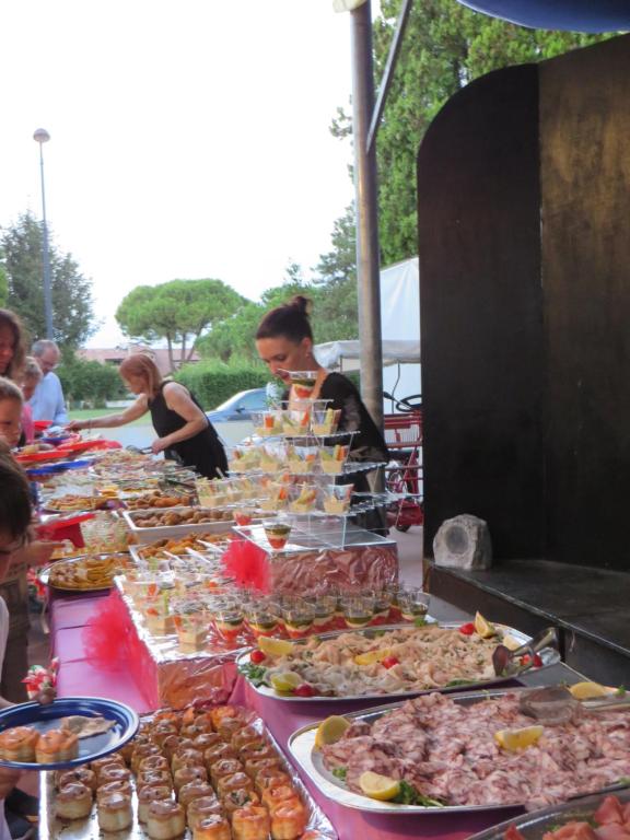 a buffet of food on a table with people at Hotel Maxim in Caorle