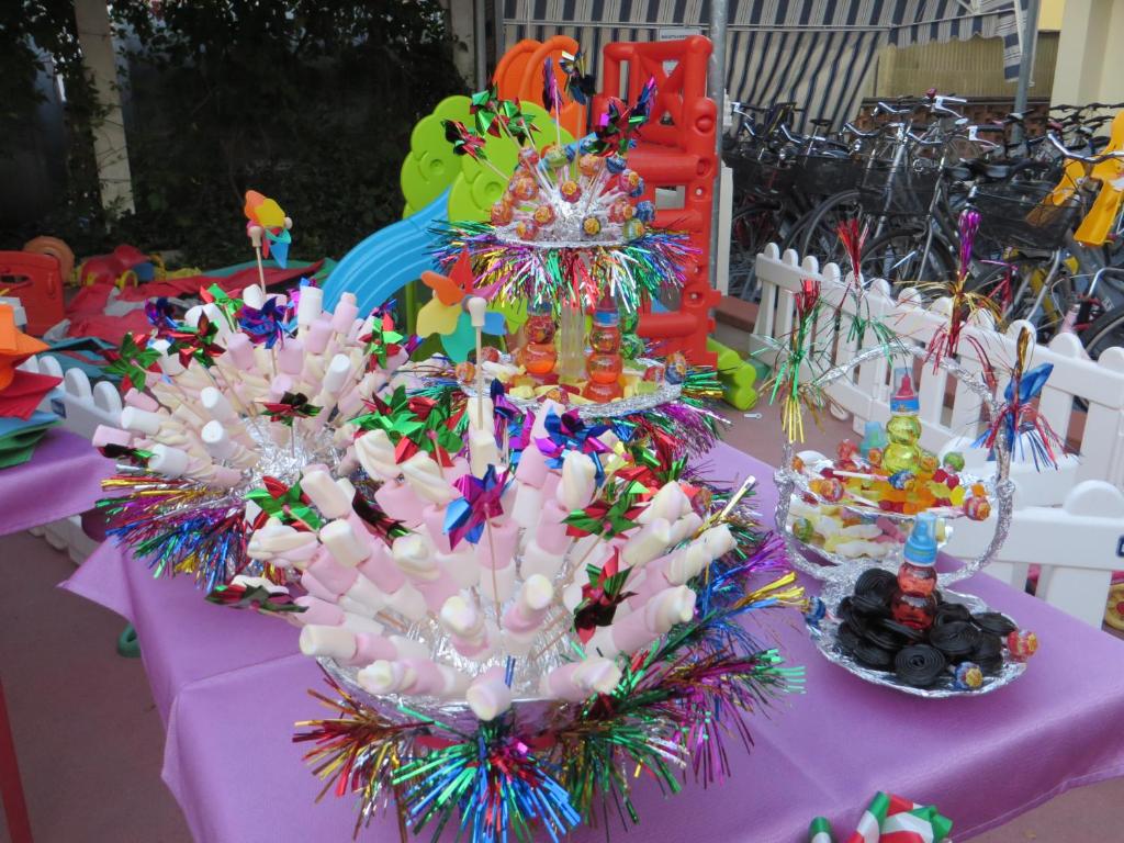 a table with a pink table cloth with candy canes and candles at Hotel Maxim in Caorle