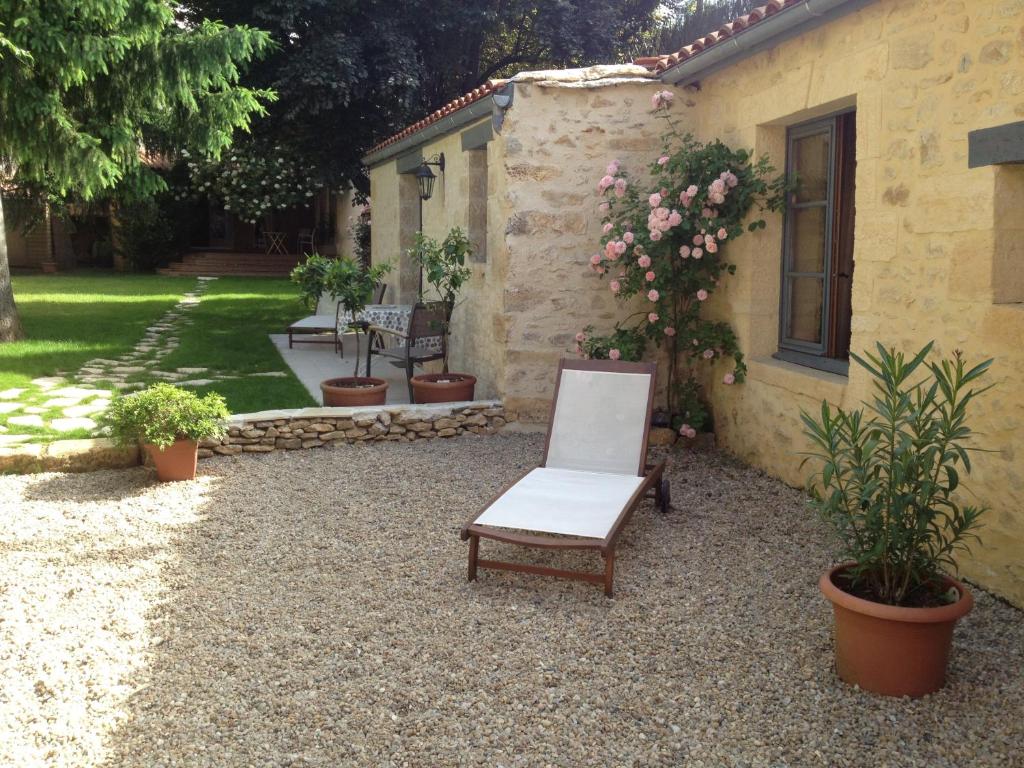 Sarlat Côté Jardin في سارلا لا كانيدا: كرسي جالس امام بيت فيه نباتات