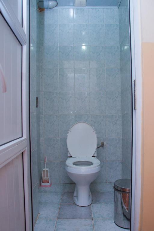 a bathroom with a toilet and a glass shower at Sakura Guesthouse in Bishkek