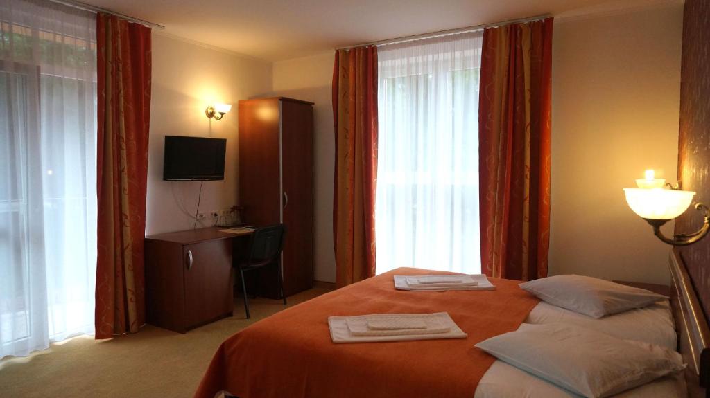 a hotel room with a bed with two towels on it at Metropol in Baile Felix