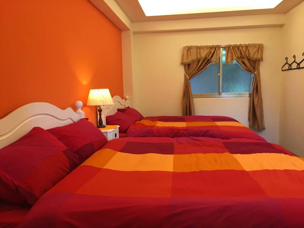 a bedroom with two beds and a window at Jiufen Golden House in Jiufen