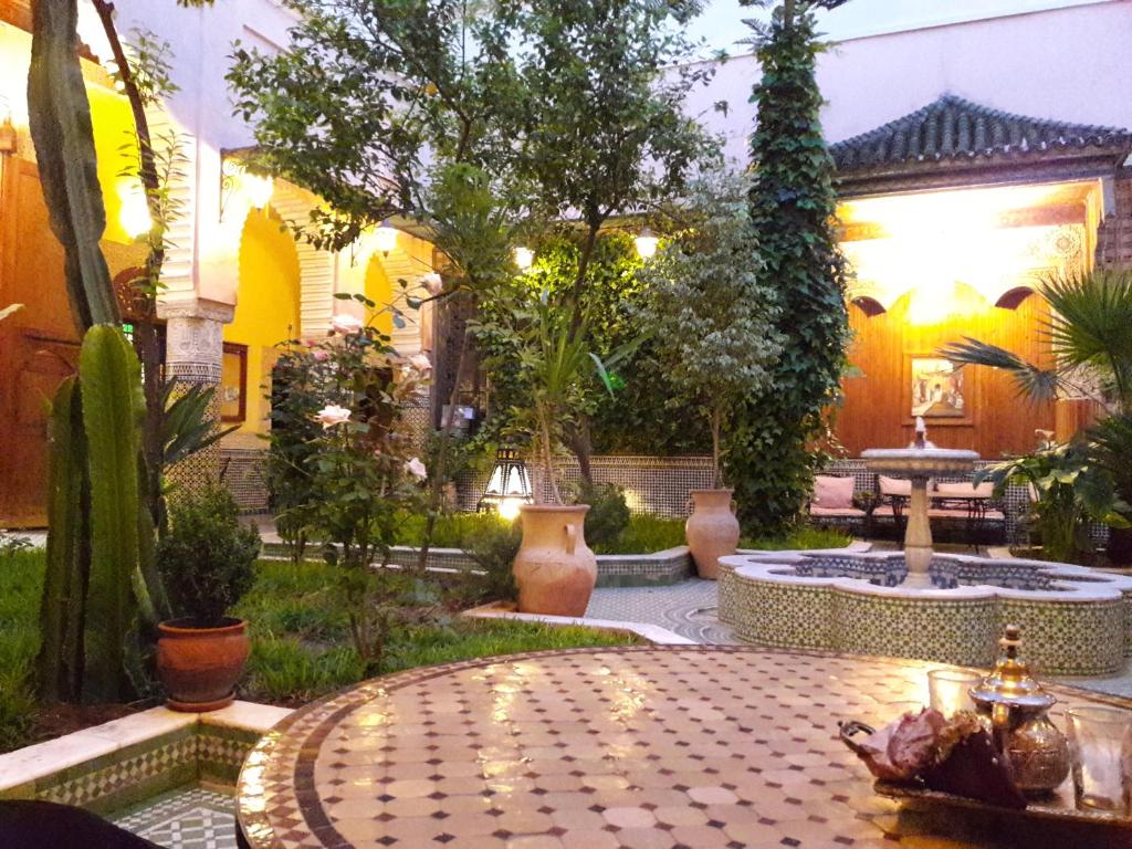 einen Garten mit einem Tisch mit Licht und Pflanzen in der Unterkunft Riad Jaouhara in Fès