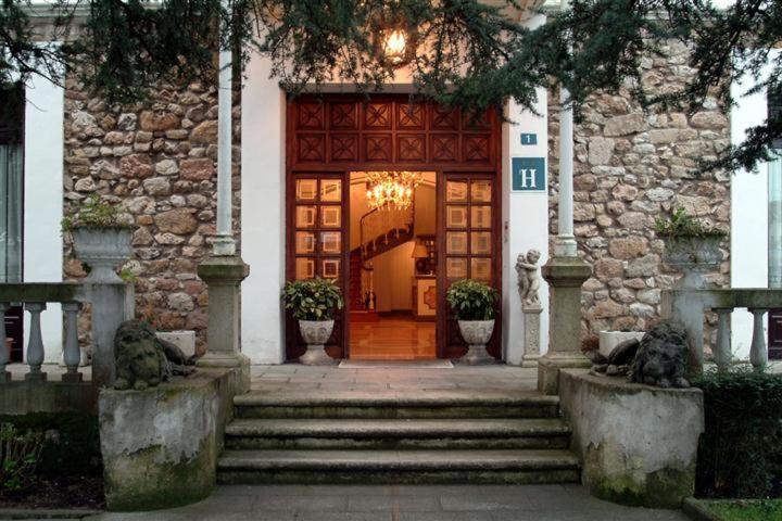 drzwi do budynku ze schodami prowadzącymi do niego w obiekcie Hotel Luzon w mieście San Vicente de la Barquera