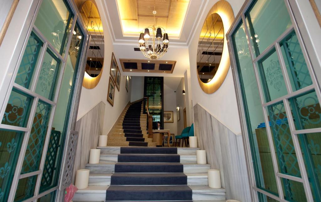 a staircase in a building with a chandelier at Collage Pera Hotel in Istanbul