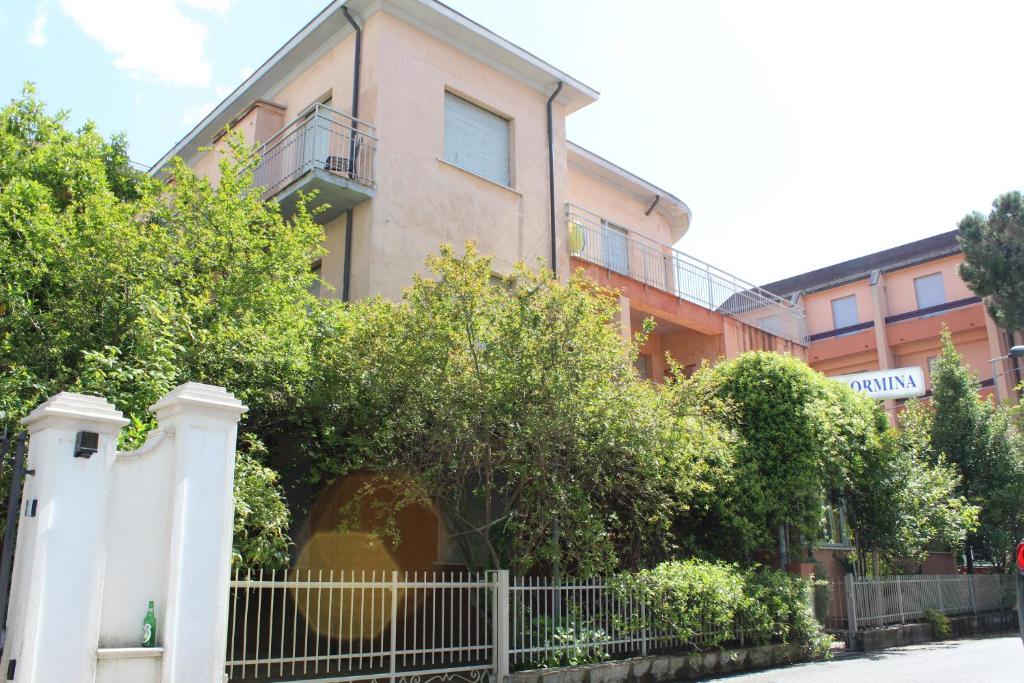 a house with a white fence in front of it at Hotel Taormina in Rimini