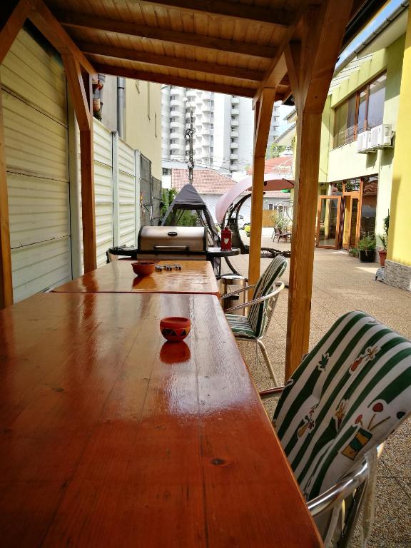 a long wooden table and chairs on a patio at Pensiunea Silvia in Baile Felix