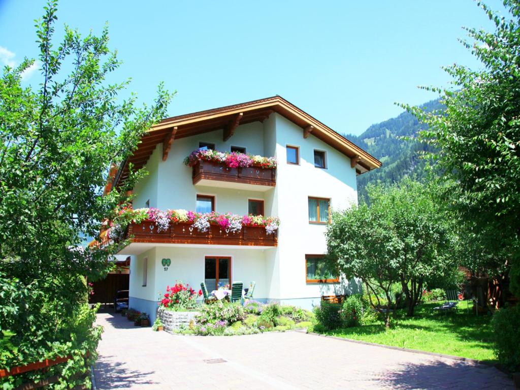 a large white house with flowers on it at Gästehaus Toferer in Grossarl