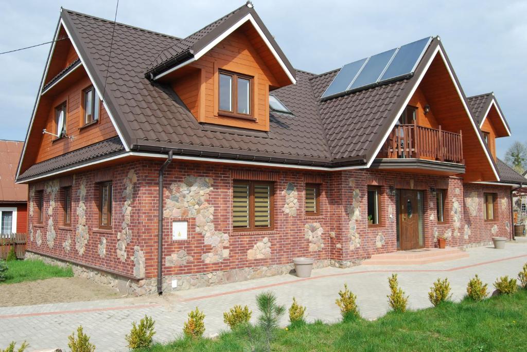 a house with solar panels on the roof at Kamienna Zagroda in Białowieża