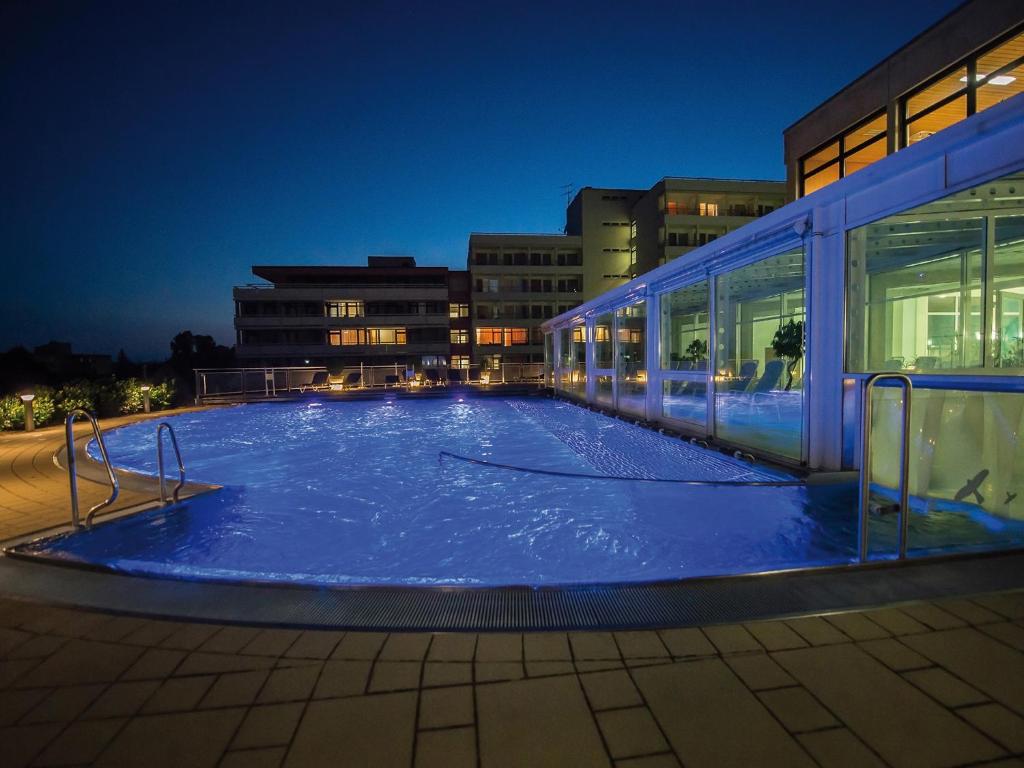 a large swimming pool in front of a building at night at feelMOOR - Gesundresort Bad Wurzach in Bad Wurzach
