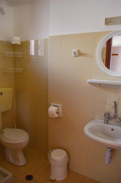 łazienka z toaletą, umywalką i lustrem w obiekcie Romantza w Skáli