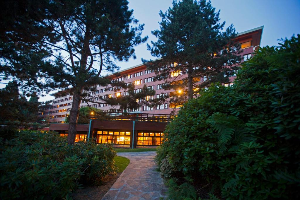 un gran edificio con luces encendidas delante de él en Disney Sequoia Lodge, en Coupvray