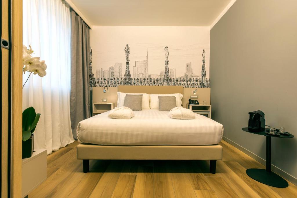 ein Schlafzimmer mit einem großen Bett mit weißer Bettwäsche in der Unterkunft 43 Station Hotel in Mailand