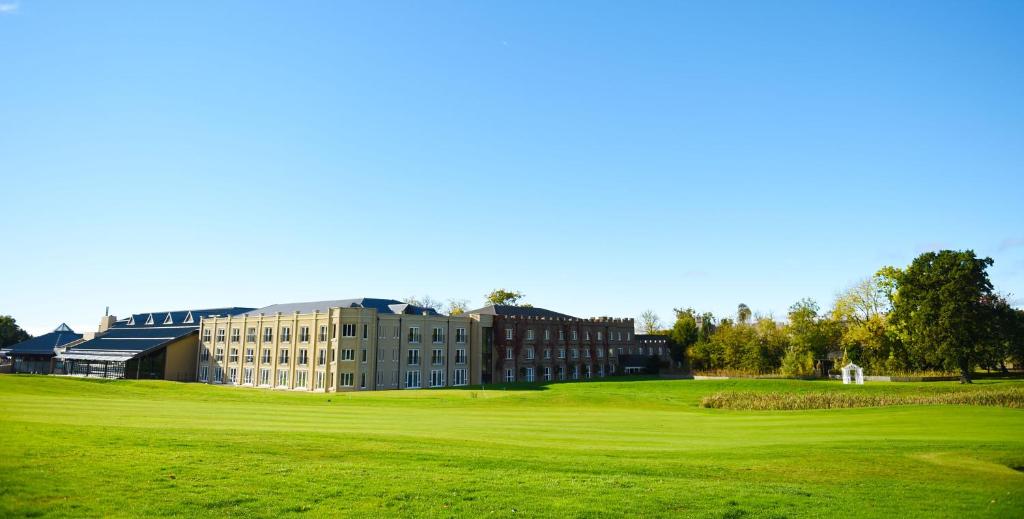 
a large green building with a grassy field at Ramside Hall Hotel, Golf & Spa in Durham
