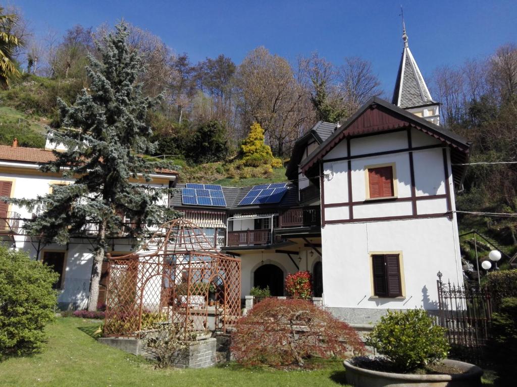 uma casa antiga com painéis solares no telhado em Villa Ombrosa em Nebbiuno