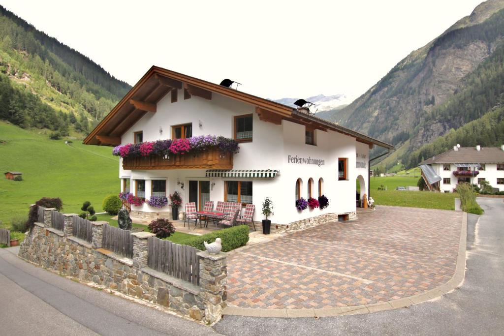 a white house with flowers on the side of it at Apart Harmonie in Kaunertal