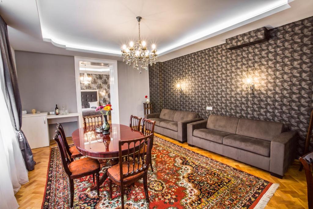 uma sala de estar com uma mesa e um sofá em Weidner Apartments em Sibiu