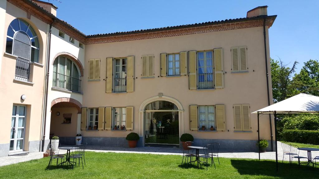 een gebouw met stoelen en tafels in een tuin bij La Regibussa - Hotel Ristorante in Asti