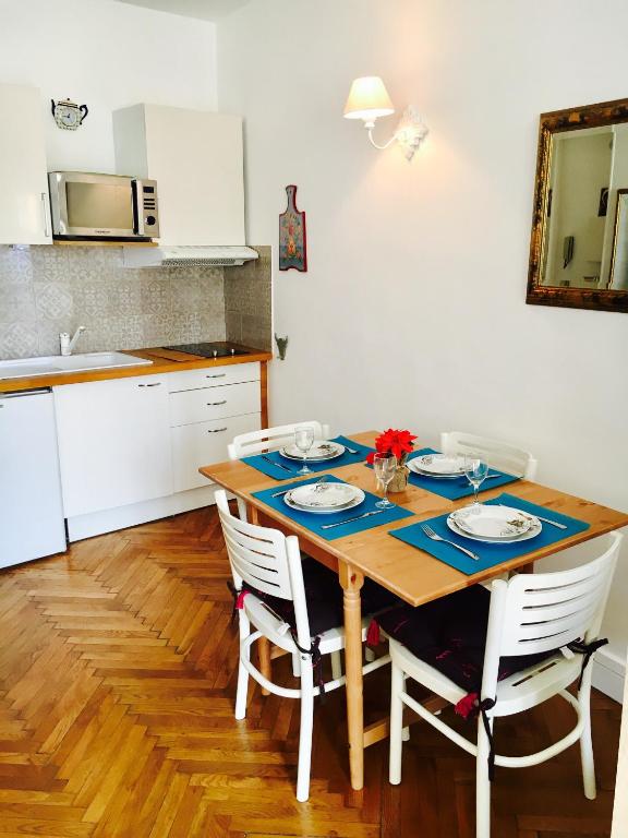 une cuisine avec une table en bois et 4 chaises dans l'établissement Studio Rue Massena, à Nice