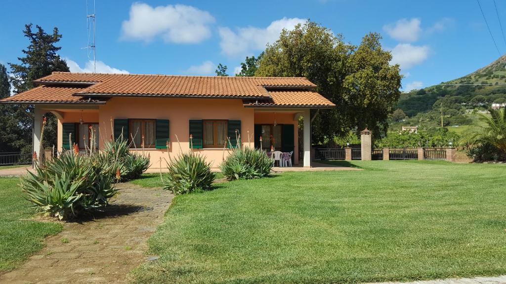 a small house with a green lawn in front of it at Agriturismo Rebua in Porto Azzurro