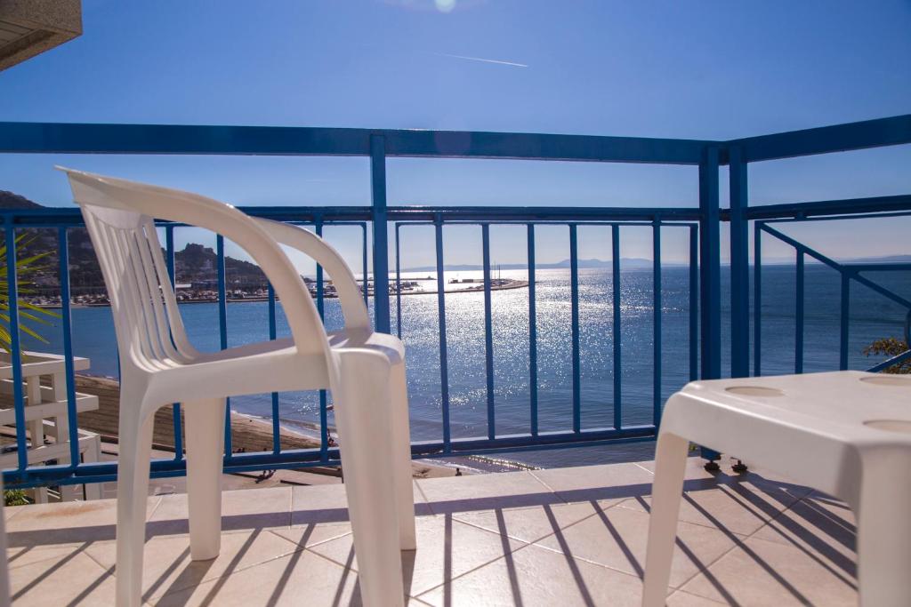 una sedia bianca e un tavolo sul balcone di Hotel Ramblamar a Roses