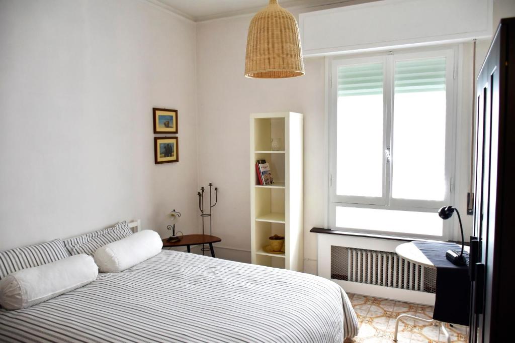 a white bedroom with a bed and a window at A casa del cuoco in Florence