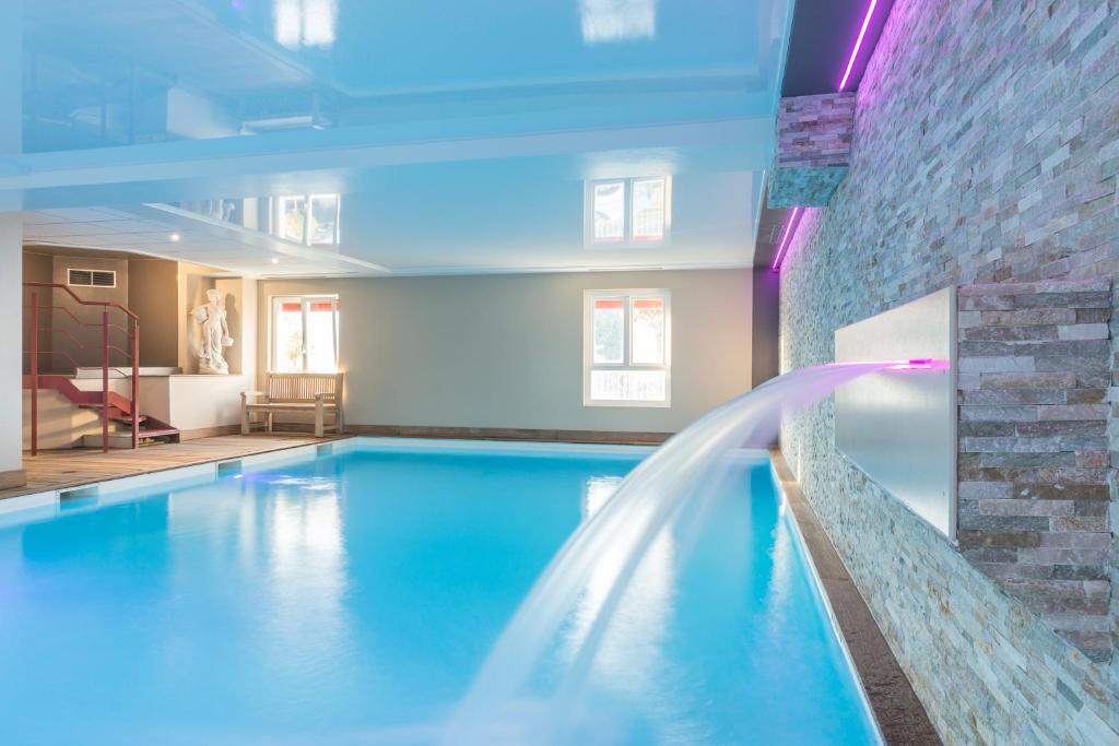 une grande piscine avec une fontaine dans l'établissement Résidence La Closerie Deauville, à Deauville