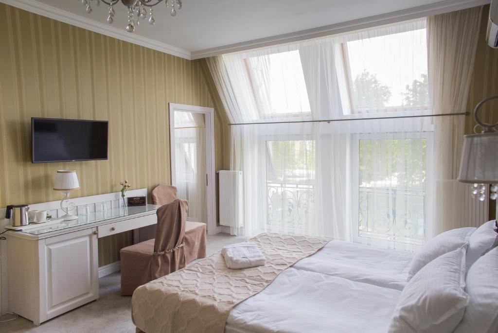 een slaapkamer met een bed, een bureau en een televisie bij Boutique Hotel Deluxe in Kamjanets-Podilsky