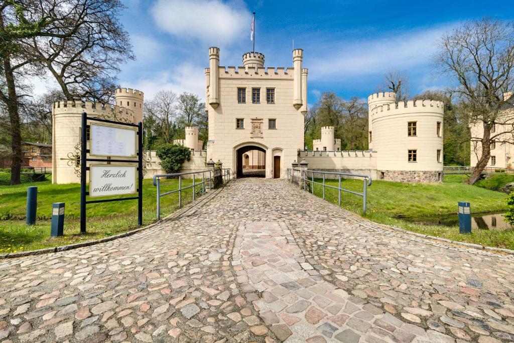 um castelo com uma estrada de paralelepípedos que o conduz em Hotel Jagdschloss Letzlingen em Letzlingen