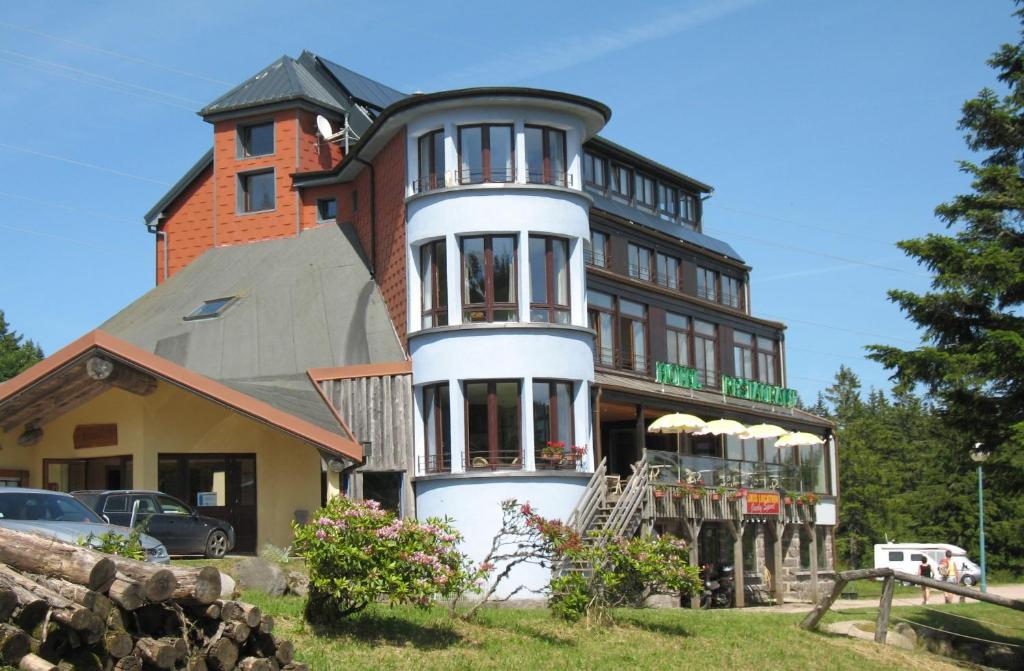 a large house with a porch on top of it at Les Terrasses du Lac Blanc - Studios & Appartements in Orbey