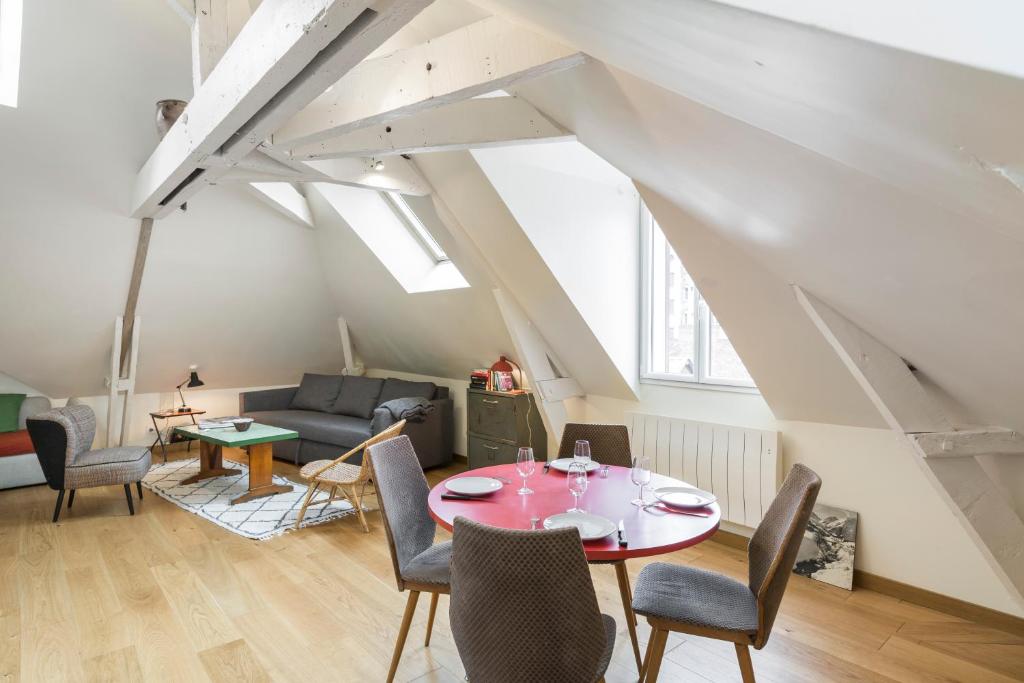 - un salon avec une table et des chaises rouges dans l'établissement Odorico by Cocoonr, à Rennes