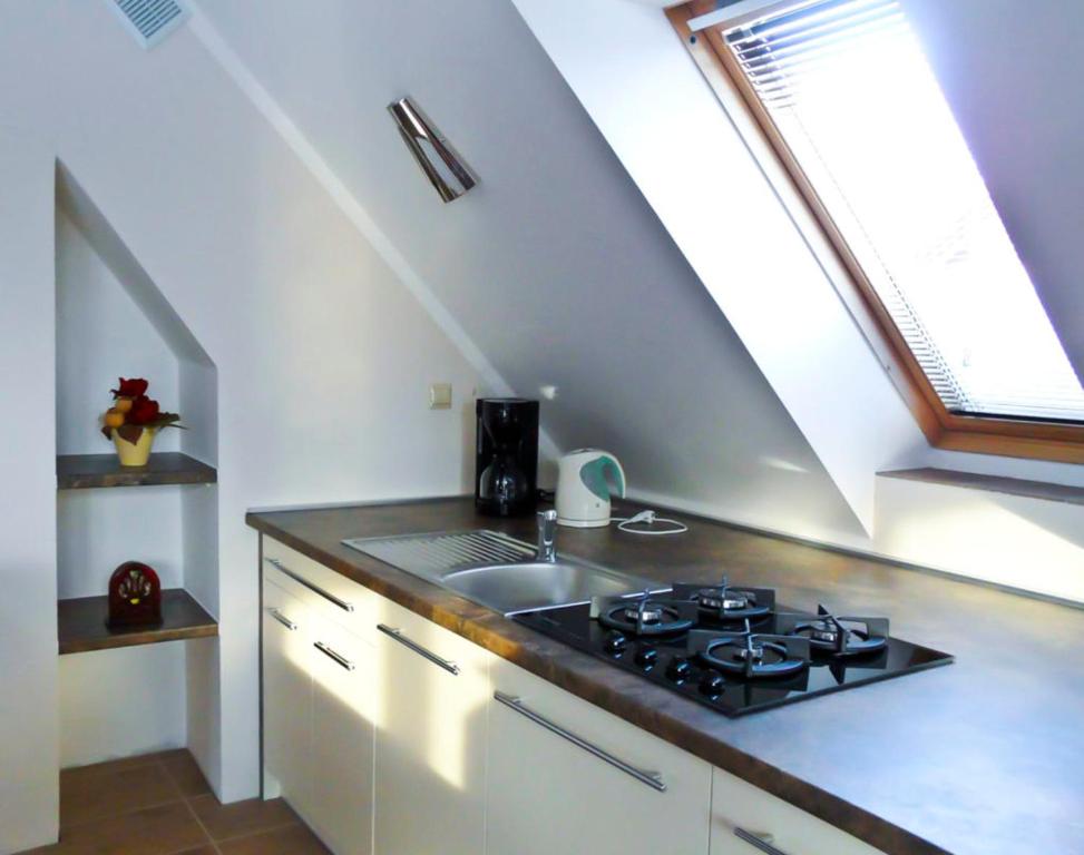 a kitchen with a stove and a sink at Apartamenty Mitori in Dywity