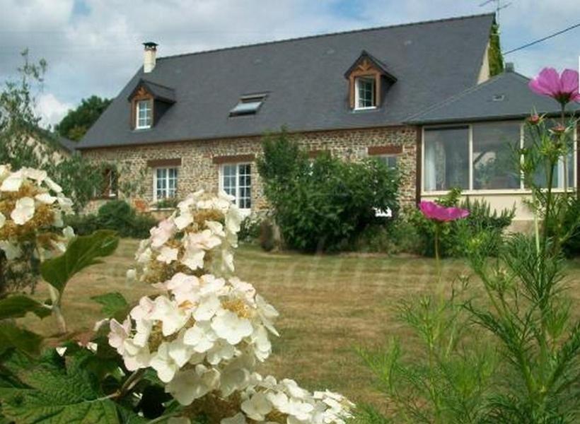 a brick house with flowers in front of it at Chambres d'Hôtes Le Clos Vaucelle in Rapilly