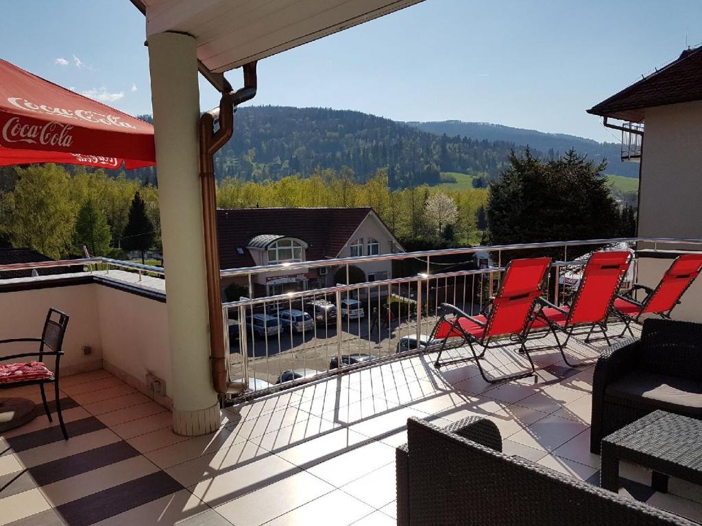 a balcony with chairs and a view of the mountains at Hawana Pensjonat & SPA in Brenna